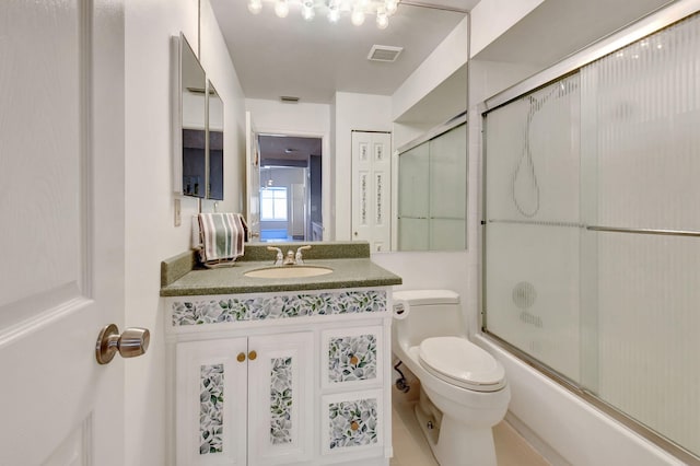 full bath featuring visible vents, vanity, toilet, and combined bath / shower with glass door