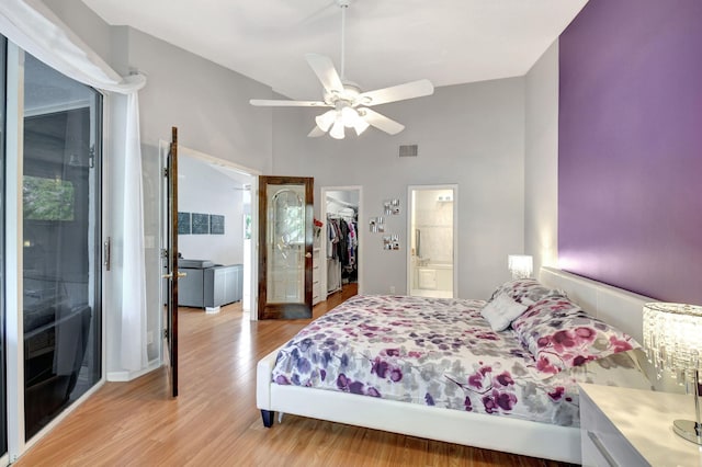 bedroom featuring visible vents, a ceiling fan, a closet, light wood finished floors, and a walk in closet