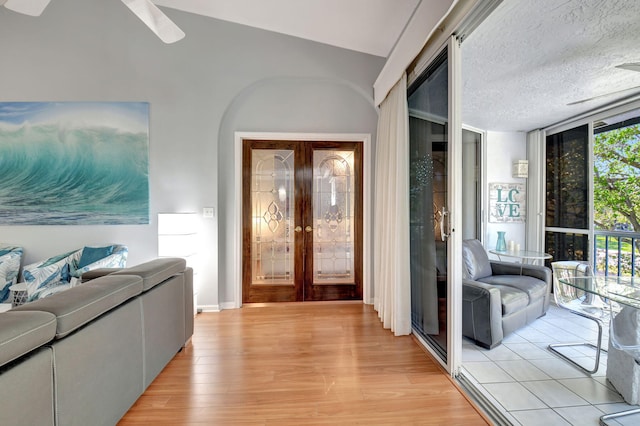 entryway featuring light wood-type flooring, french doors, a textured ceiling, and expansive windows