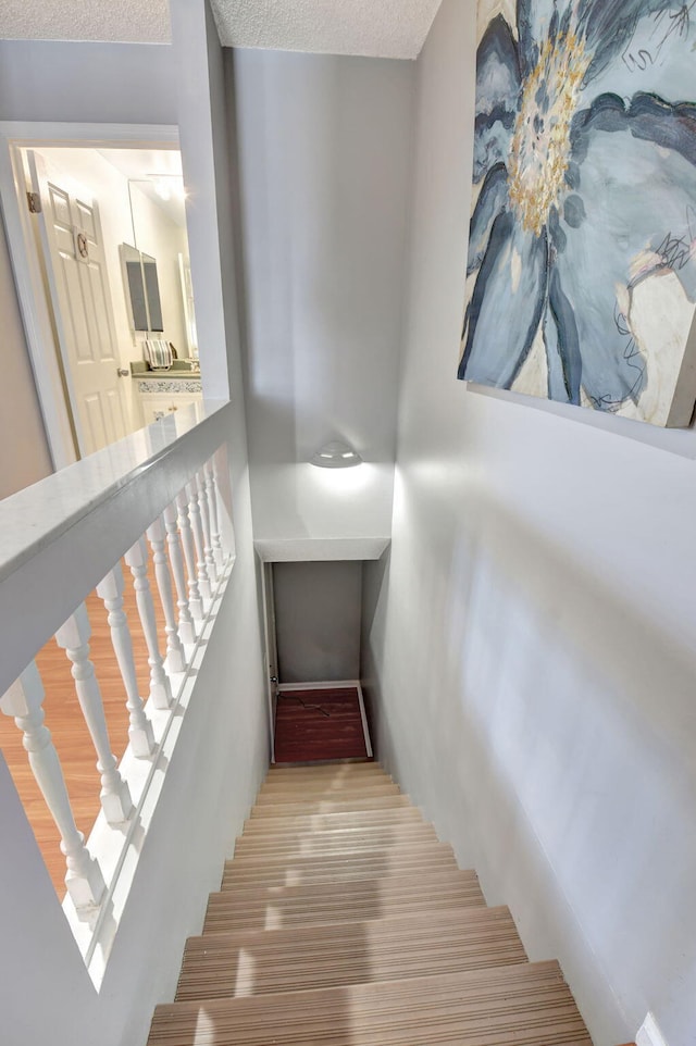 stairway with a textured ceiling