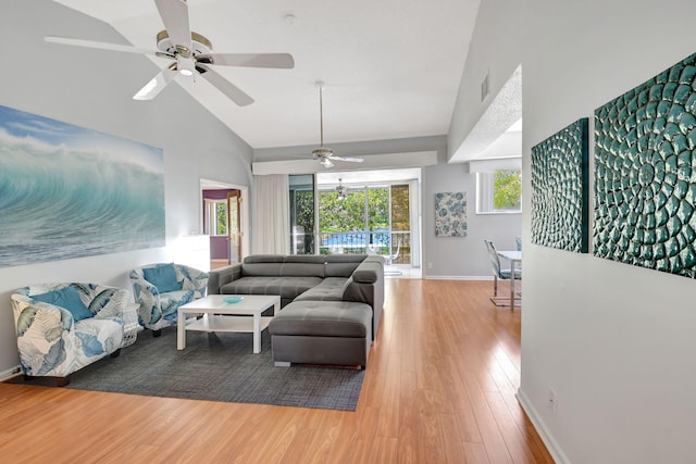 living room with high vaulted ceiling, visible vents, baseboards, and wood finished floors