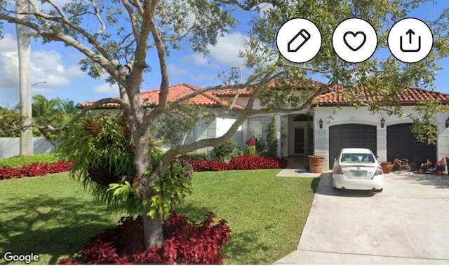 mediterranean / spanish-style house with driveway, a front lawn, an attached garage, and a tile roof