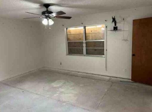 unfurnished room featuring ceiling fan and concrete flooring