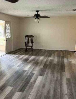 interior space featuring a textured ceiling, wood finished floors, and a ceiling fan