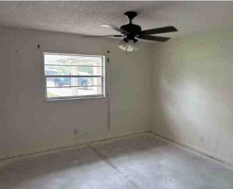 spare room with a textured ceiling and ceiling fan