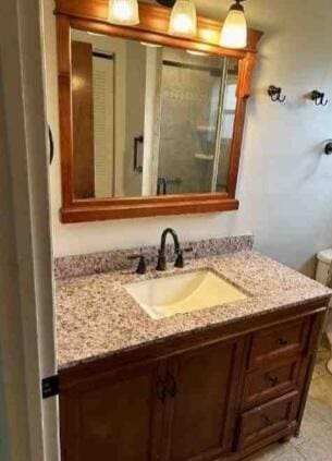 bathroom with a stall shower, vanity, and tile patterned floors