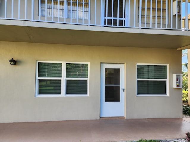 property entrance with a patio and stucco siding