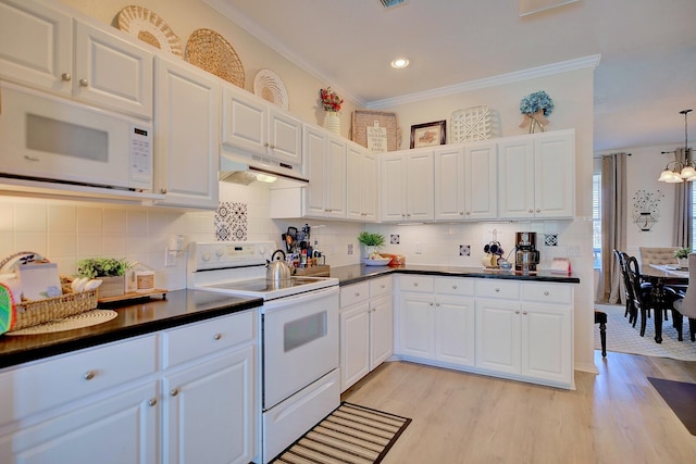 kitchen with dark countertops, light wood-style flooring, ornamental molding, white appliances, and under cabinet range hood