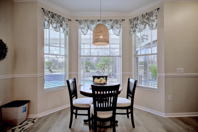 dining space featuring a healthy amount of sunlight, light wood-style floors, and crown molding