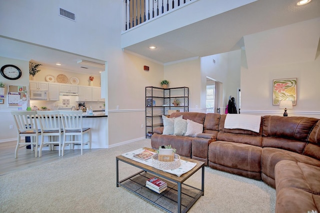 living room featuring crown molding, recessed lighting, visible vents, a towering ceiling, and baseboards