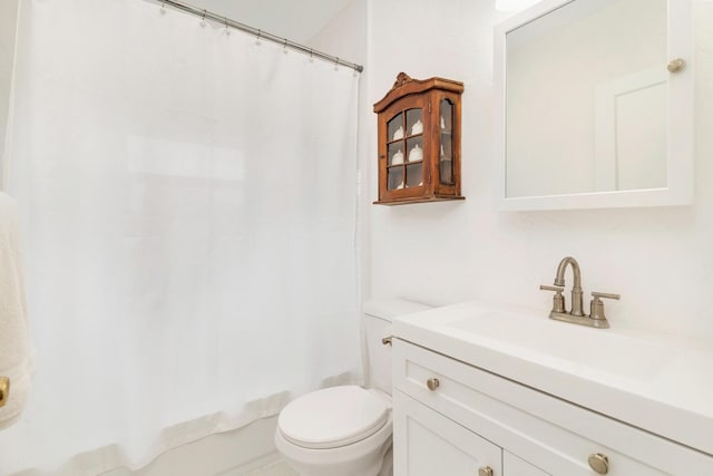 bathroom featuring toilet, shower / tub combo with curtain, and vanity