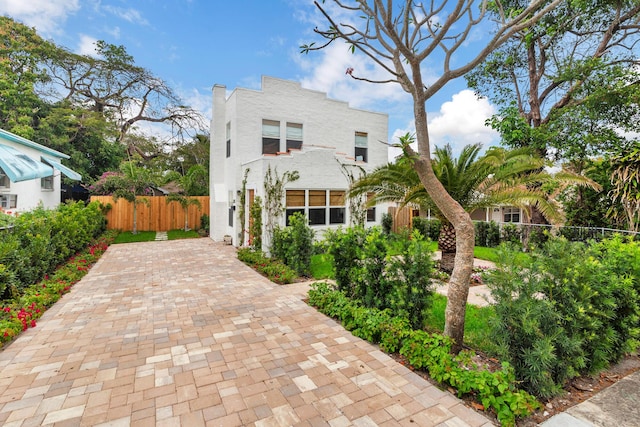 mediterranean / spanish home featuring fence and stucco siding