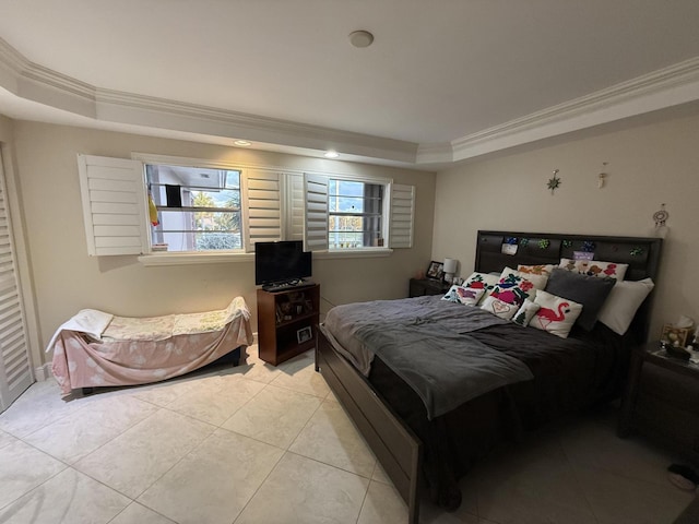 bedroom featuring ornamental molding, a raised ceiling, and light tile patterned floors