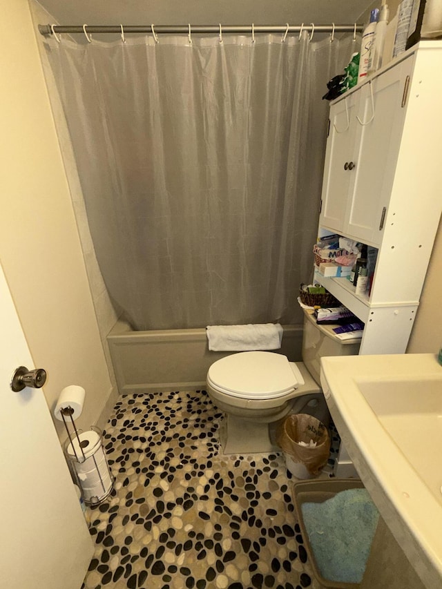 bathroom featuring shower / tub combo, a sink, and toilet