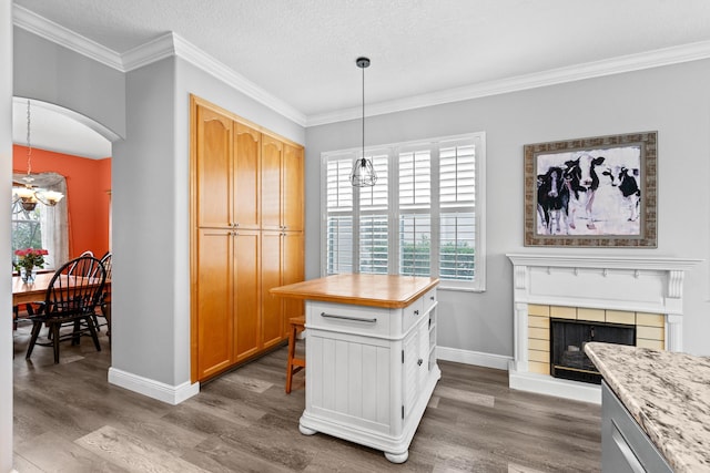 kitchen with arched walkways, wood finished floors, and light countertops