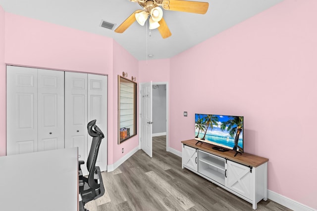 office space with visible vents, baseboards, light wood-style floors, and a ceiling fan