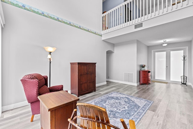 sitting room with visible vents, arched walkways, and baseboards