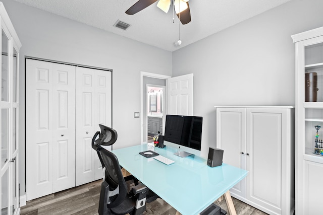 office space with visible vents, a textured ceiling, a ceiling fan, and wood finished floors