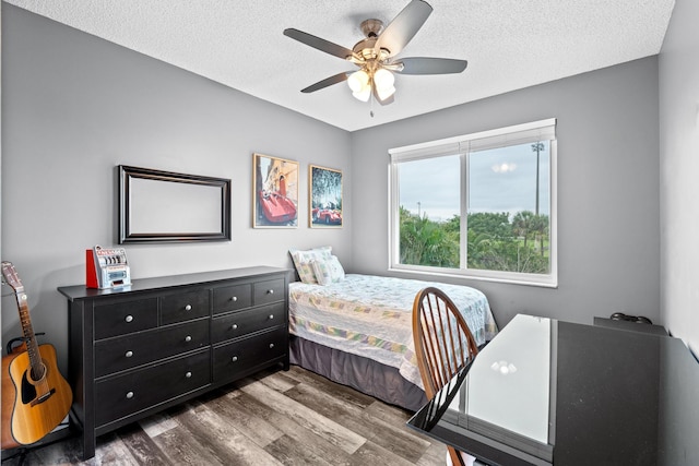 bedroom with a textured ceiling, wood finished floors, and a ceiling fan