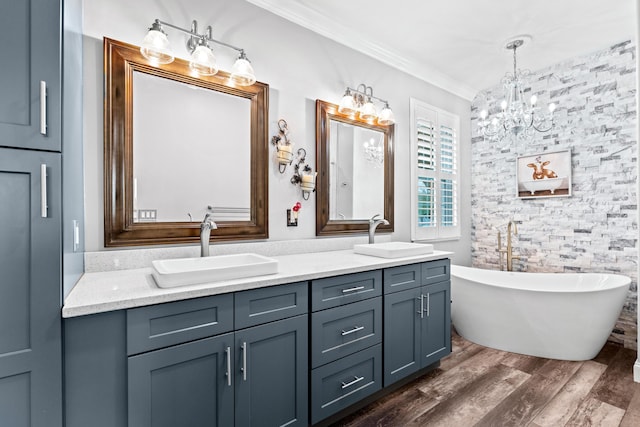 full bathroom featuring a sink, wood finished floors, ornamental molding, and double vanity