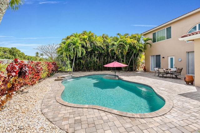 pool featuring fence and a patio area