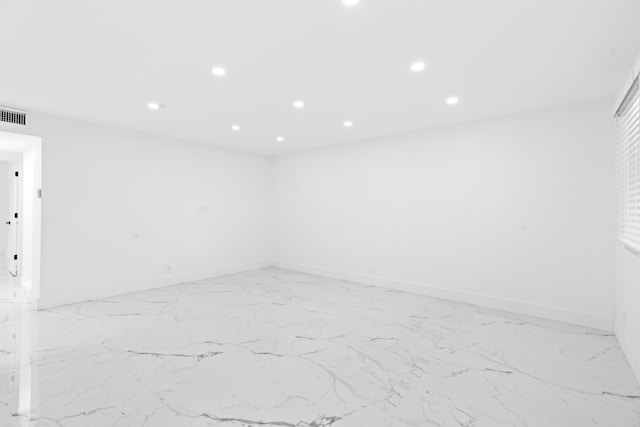 spare room with marble finish floor, visible vents, baseboards, and recessed lighting