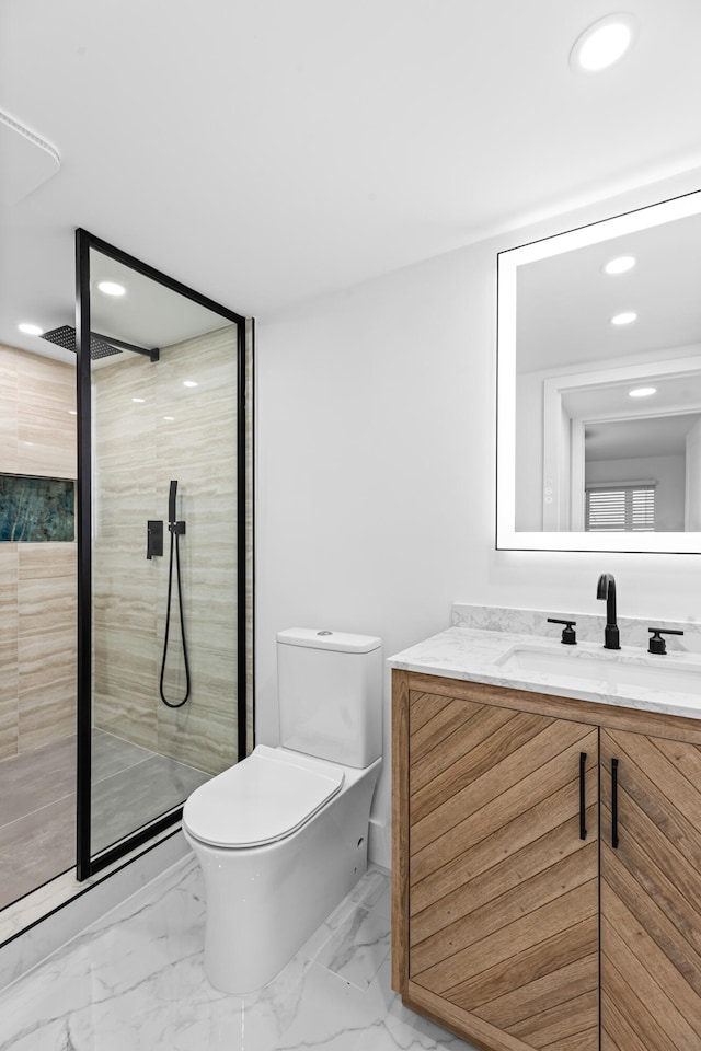 bathroom featuring marble finish floor, vanity, a shower stall, and toilet