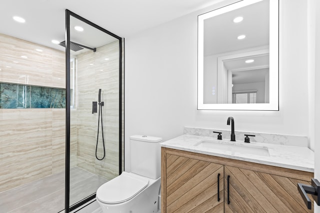 bathroom with recessed lighting, a tile shower, vanity, and toilet