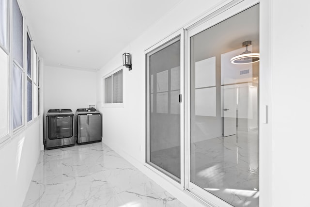 interior space featuring marble finish floor, washing machine and dryer, and visible vents