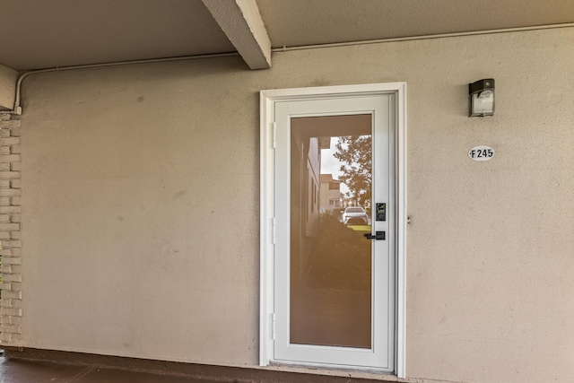 doorway to property featuring stucco siding