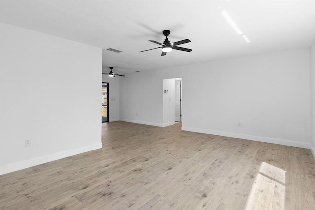 spare room featuring light wood-style floors, visible vents, baseboards, and a ceiling fan