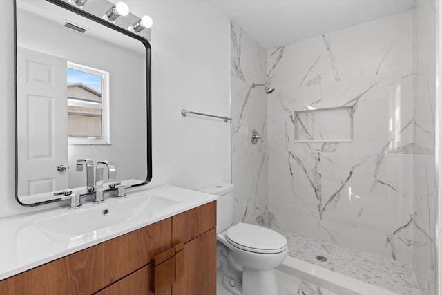 full bathroom featuring marble finish floor, a marble finish shower, visible vents, toilet, and vanity