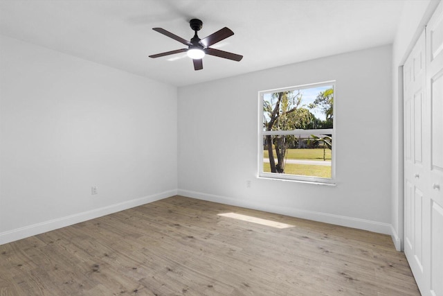 unfurnished bedroom with a closet, baseboards, and wood finished floors