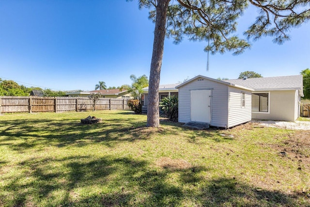 view of yard with a storage shed, a fenced backyard, and an outdoor structure