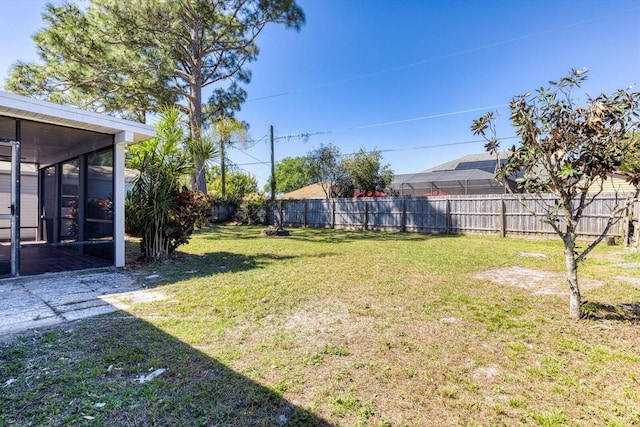 view of yard featuring a sunroom and a fenced backyard