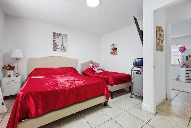 bedroom with tile patterned floors and a textured ceiling