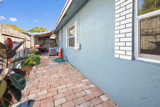 view of patio with central AC and fence