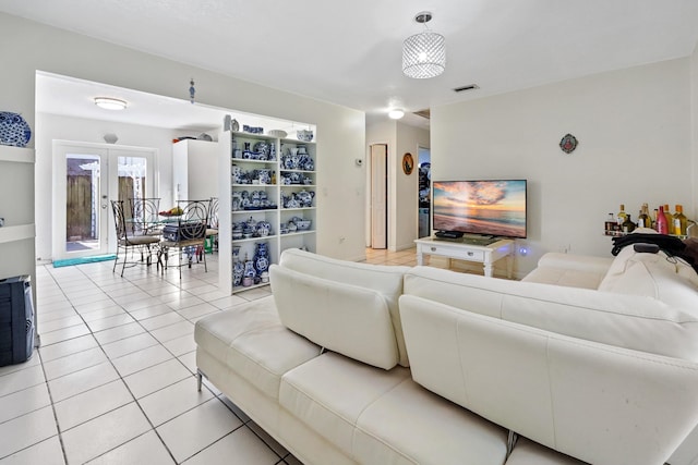 living area featuring light tile patterned floors, french doors, and visible vents