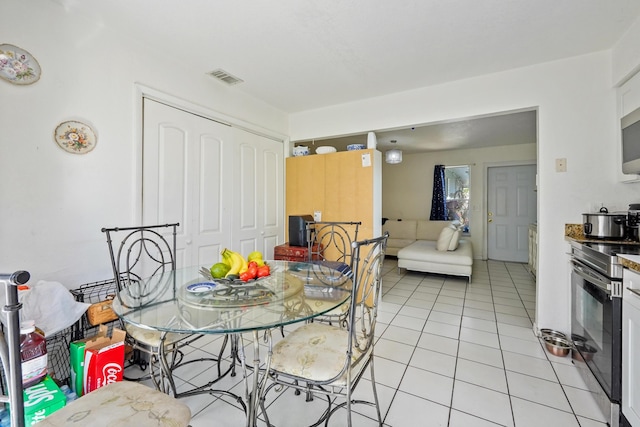 dining space with light tile patterned floors and visible vents