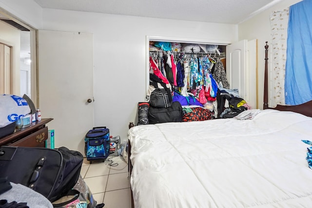 tiled bedroom featuring a closet and a textured ceiling