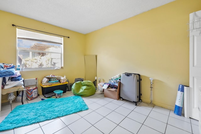 recreation room featuring light tile patterned floors and a textured ceiling