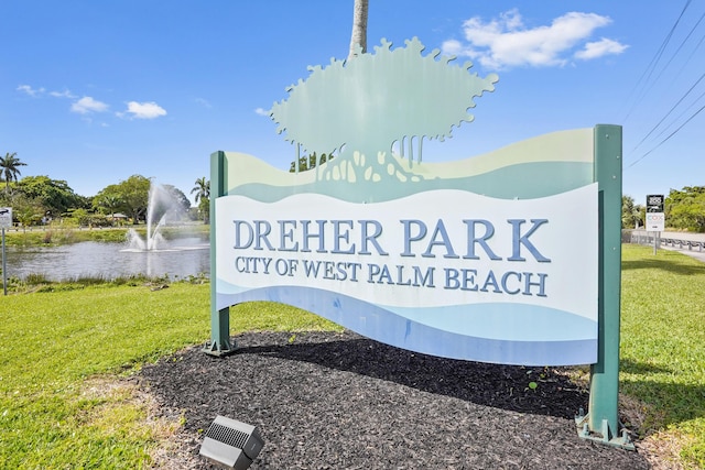 community / neighborhood sign with a yard and a water view