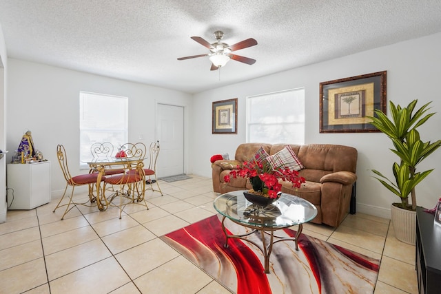 living room featuring a ceiling fan, light tile patterned flooring, and a healthy amount of sunlight