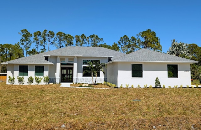 view of front of home with stone siding, roof with shingles, stucco siding, and a front yard