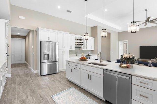 kitchen with stainless steel appliances, a sink, visible vents, white cabinetry, and light countertops