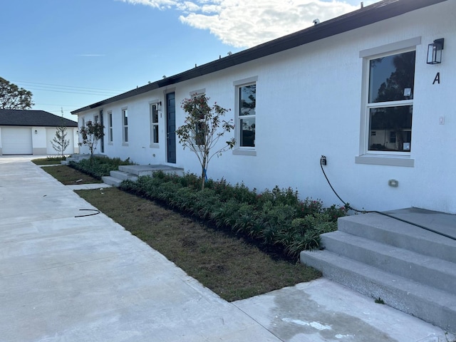 single story home featuring an outbuilding and stucco siding