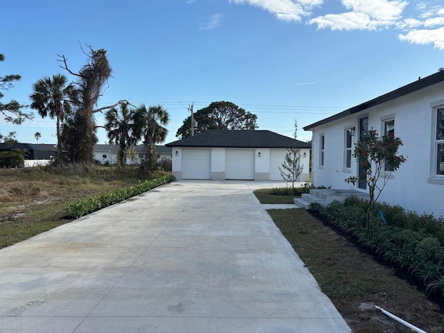 view of home's exterior with a garage, stucco siding, and an outdoor structure