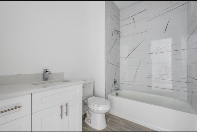 bathroom featuring toilet, wood tiled floor, shower / bathing tub combination, and vanity