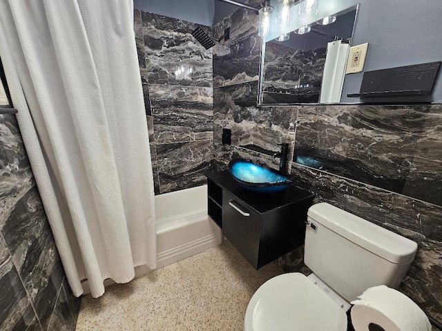 bathroom with shower / tub combo, toilet, a sink, speckled floor, and tile walls