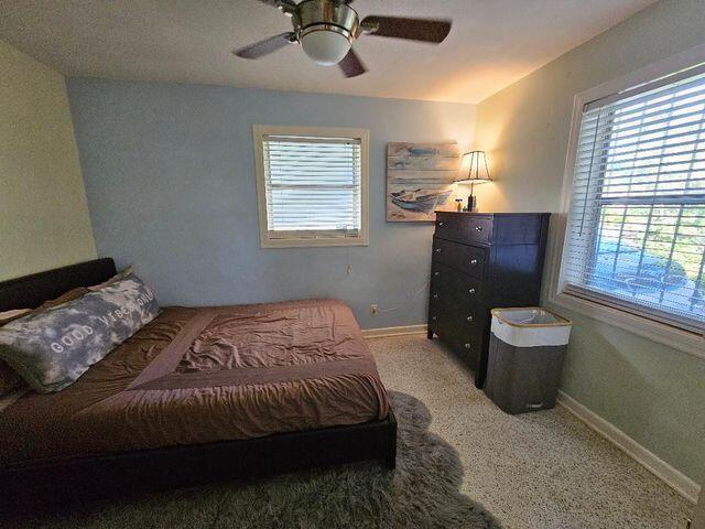 carpeted bedroom featuring a ceiling fan and baseboards